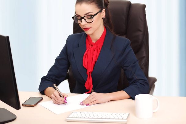 Porträt einer Geschäftsfrau mit Laptop schreibt auf ein Dokument bei ihm - Foto, Bild