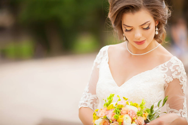 花束を保持しているウェディング ドレスの若い花嫁の肖像画 - 写真・画像
