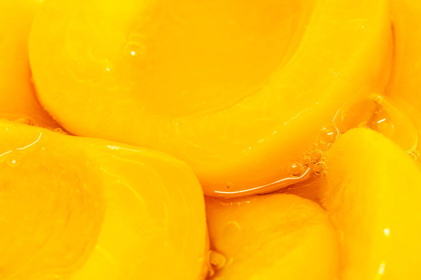 Консервированные персиковые половинки крупным планом в сиропе
 - Фото, изображение