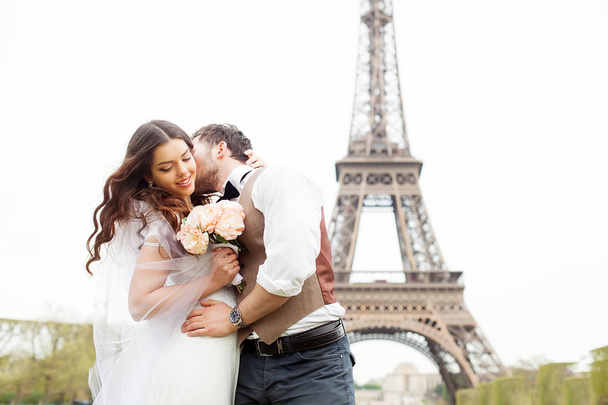 Esküvő Párizsban. Boldog házasok pár átölelve, közel az Eiffel-torony - Fotó, kép