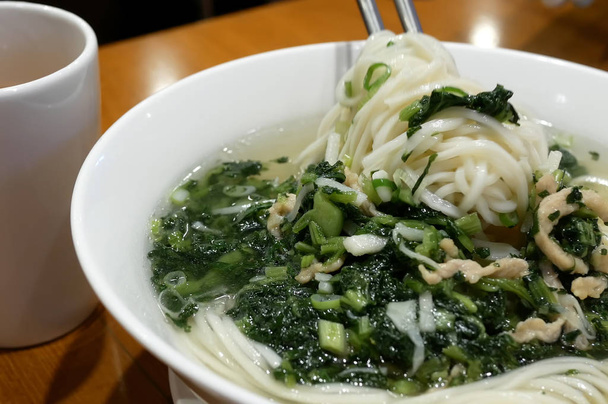 Movimiento de la mujer comiendo sopa de fideos dentro del restaurante chino
 - Foto, imagen