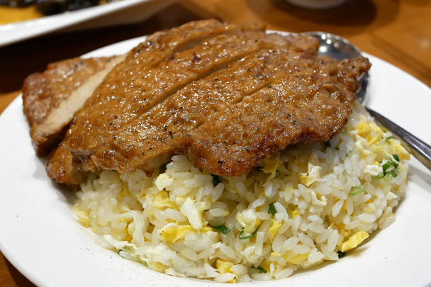 Movimiento de arroz frito con cerdo frito en la mesa dentro del restaurante chino
 - Foto, imagen