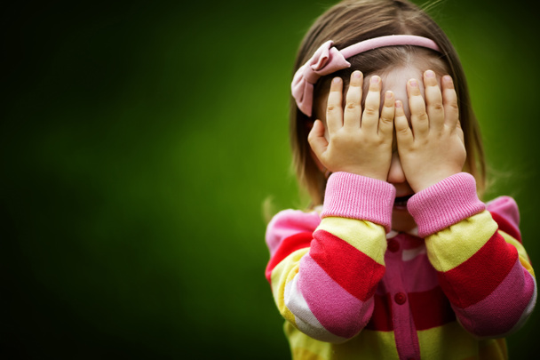 holčička hraje na schovávanou skrývá tvář - Fotografie, Obrázek