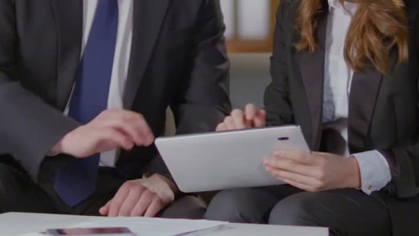 Frau zeigt Kollegin Tablet-Bildschirm, professionelle Beratung, Vertragsdetails - Filmmaterial, Video