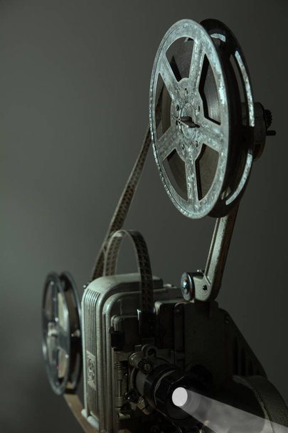 Παλιό προβολέα κινηματογράφου σε σκούρο φόντο - Φωτογραφία, εικόνα