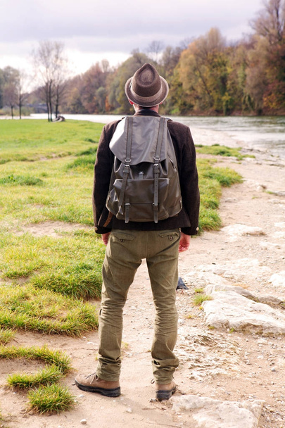 backside of bavarian man with backpack and standing by river - Fotografie, Obrázek