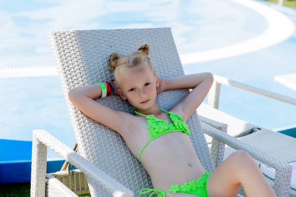 Молода дівчина в купальнику на полиці біля басейну
 - Фото, зображення