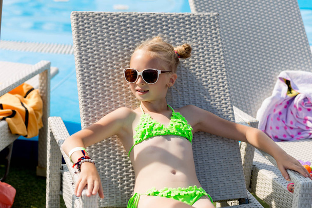 Jong meisje in een zwembroek op een plank bij het zwembad - Foto, afbeelding
