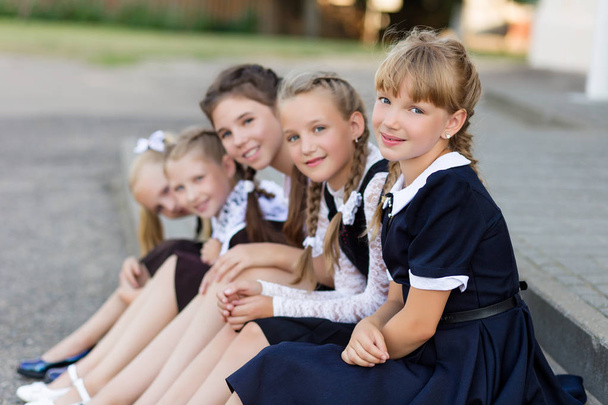 Écolières en uniforme scolaire reposer sur une pause près de l'école
 - Photo, image