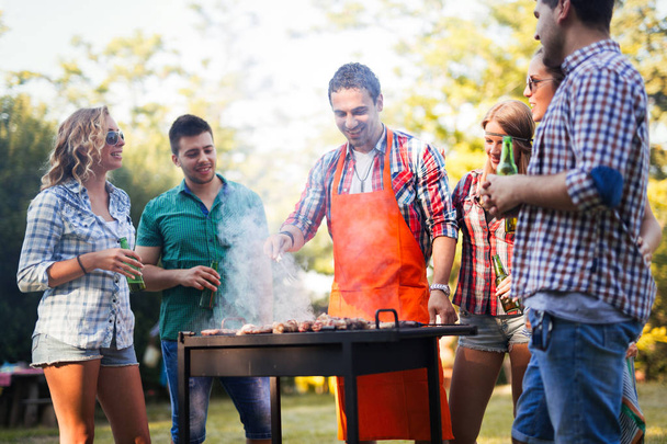 Young people enjoying barbecuing  - Фото, изображение
