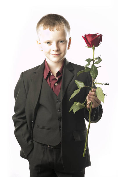 Guy with the red rose. Young man distinguished figure in a dark  - Фото, изображение