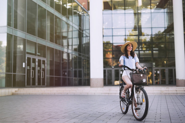 Portrait of beautiful woman enjoying time on bicycle - Фото, изображение