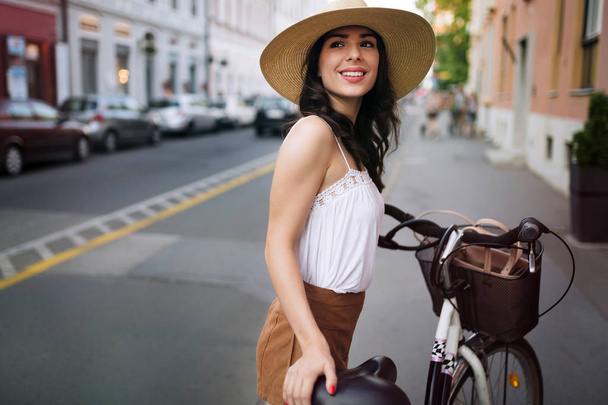 Portrait of beautiful woman enjoying time on bicycle - Foto, imagen