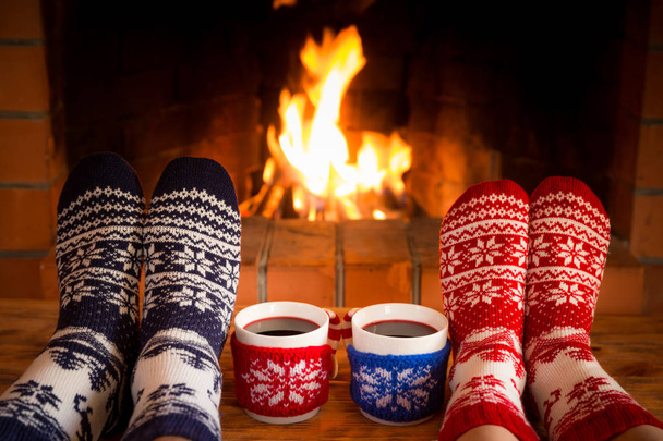 Pareja en calcetines de Navidad cerca de la chimenea
 - Foto, imagen