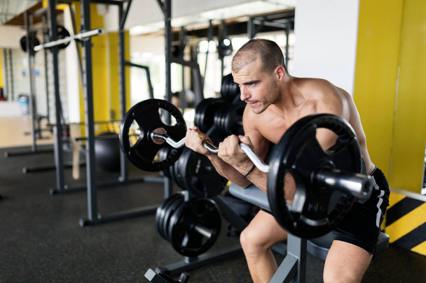 Athlete muscular bodybuilder in gym  - Foto, afbeelding