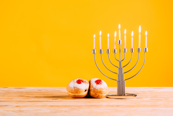 hanukkah celebrating with menorah and donuts - Foto, afbeelding