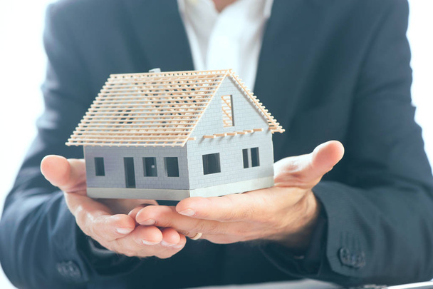 business man holding an house model in the palm of his hands - Foto, immagini