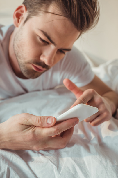 man using smartphone in bed - Zdjęcie, obraz