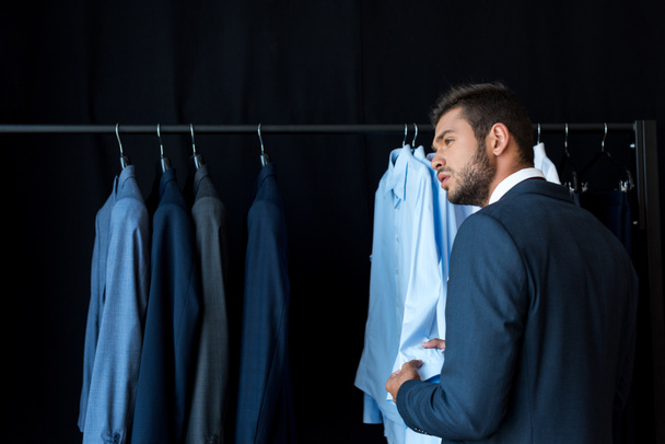 бизнесмен выбирает костюм в бутике
 - Фото, изображение