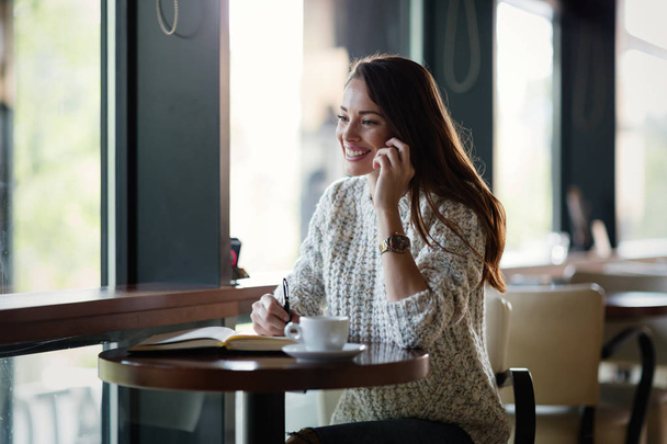 woman talking on phone in restaurant - Foto, imagen