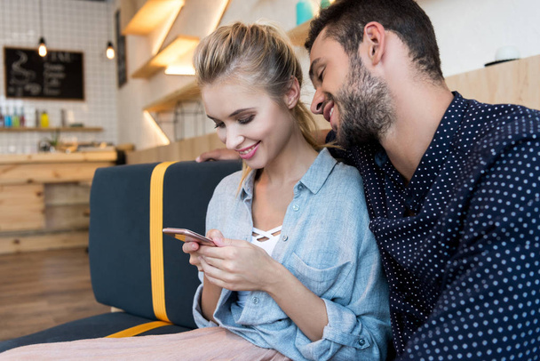 young couple with smartphone in cafe - Foto, imagen