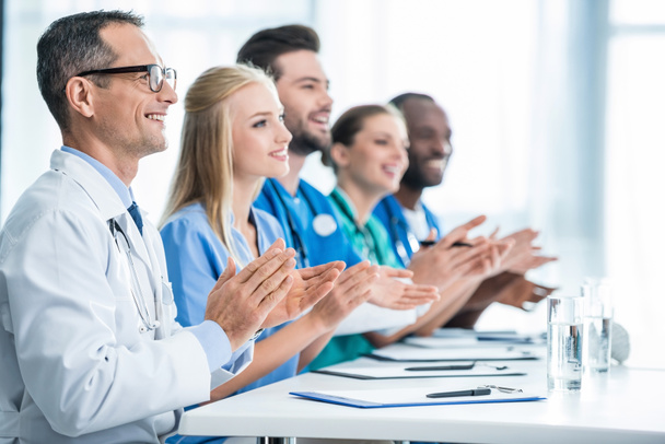 doctors sitting at table and clapping - Photo, Image
