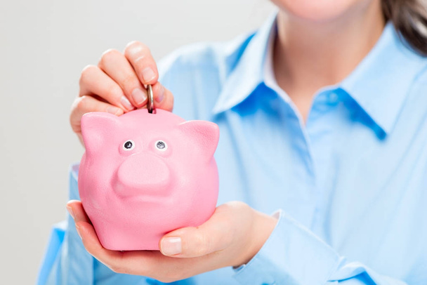 Hände mit einem rosafarbenen Sparschwein in Großaufnahme - das Konzept des Geldes nach - Foto, Bild