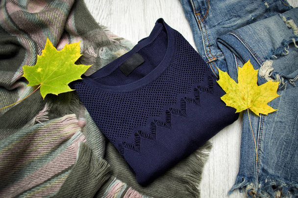 Jersey azul, bufanda, jeans y hojas de arce. Concepto de moda
 - Foto, Imagen
