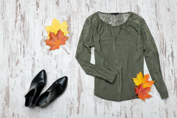 Блузка Хаки, черные сапоги и кленовые листья. Модная концепция
. - Фото, изображение