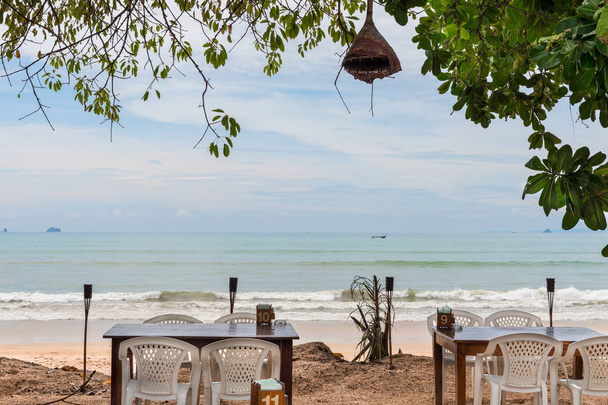 εστιατόριο δίπλα στη θάλασσα στην ύπαιθρο κάτω από τη σκιά ενός δέντρου - Φωτογραφία, εικόνα