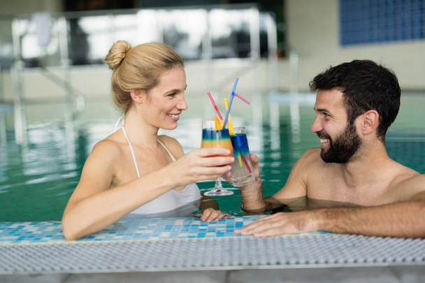 happy couple relaxing in pool - Φωτογραφία, εικόνα