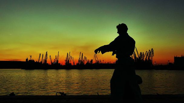 σιλουέτα ενός μαχητή του Τάε Κβον Ντο στο ηλιοβασίλεμα πάνω από τη θάλασσα - Φωτογραφία, εικόνα