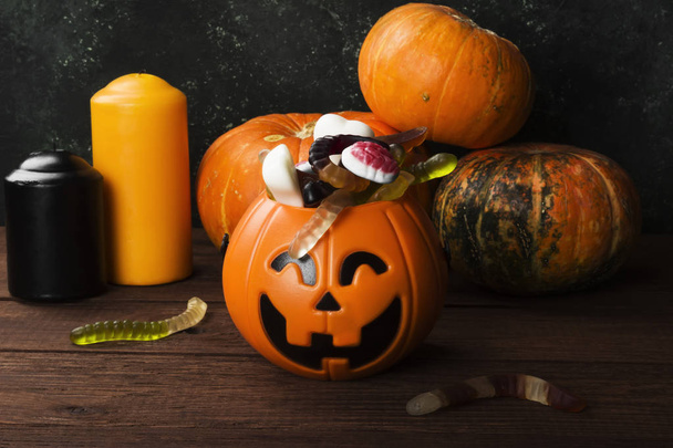 Terrible sweets for Halloween in decorative pumpkin on a dark ba - Foto, afbeelding