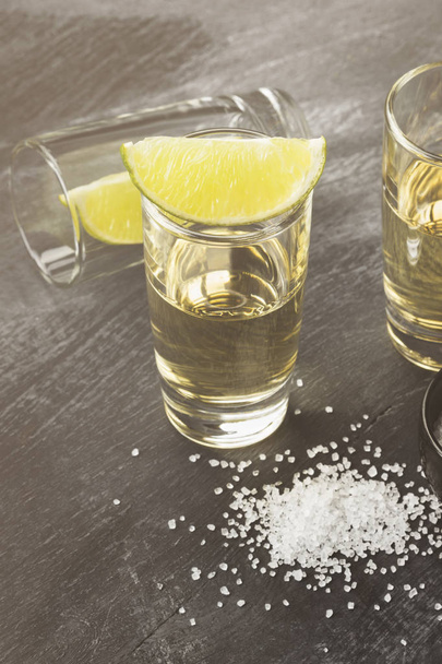 Tequila with lime and salt on a dark background. Toned - Foto, Imagen
