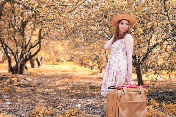 girl with leather suitcase for travel in the autumn park on walk - Foto, Bild