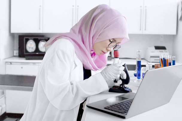 Young chemist working with microscope - Zdjęcie, obraz