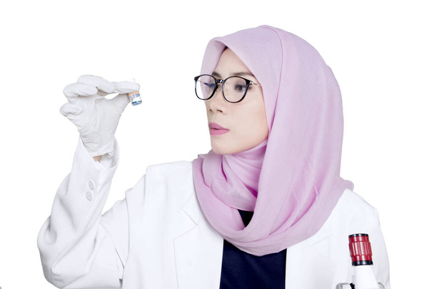 Muslim scientist holds small bottle - Foto, Bild