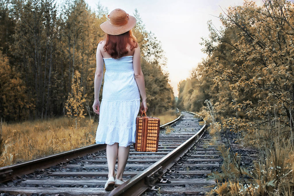 chica del parque de otoño en vestido blanco y una maleta de mimbre caminando
 - Foto, Imagen