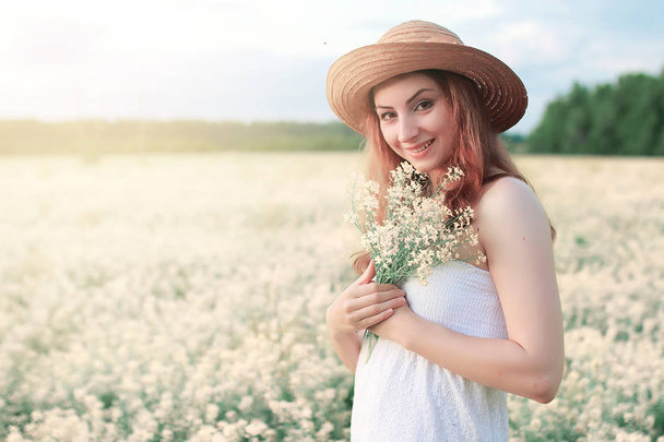 Girl in white dress in a field of yellow flowers blossoming - Photo, Image