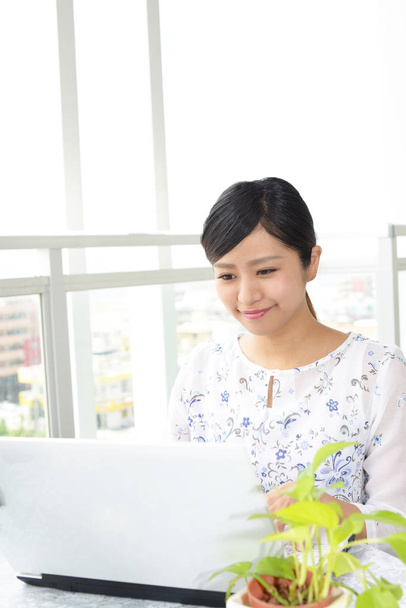 Mulher sorridente usando um laptop
 - Foto, Imagem