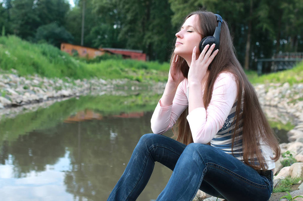 chica escuchar música en auriculares al aire libre
 - Foto, imagen