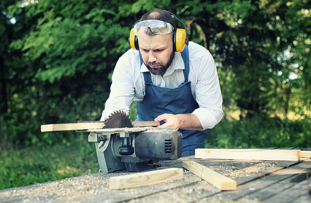 worker beard man with circular saw - Photo, Image