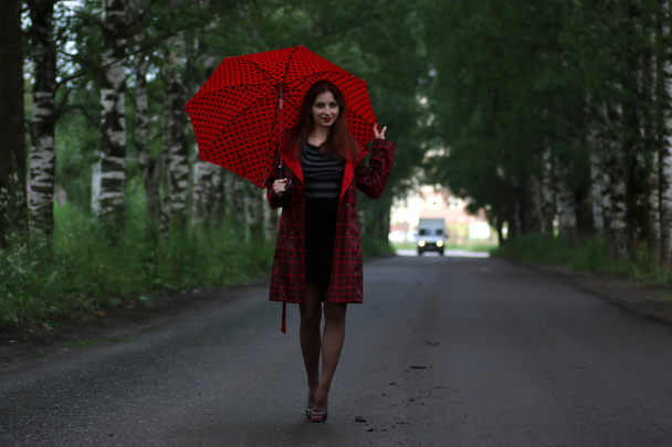 nainen sadetakki ja sateenvarjo
 - Valokuva, kuva
