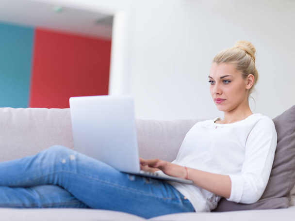 Young woman using laptop at home - Fotó, kép
