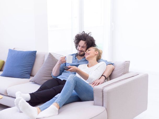 Young couple on the sofa watching television - Valokuva, kuva