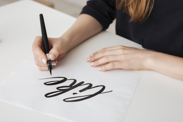 Lähikuva kuva nuori nainen kädet kirjallisesti paperille pöydälle eristetty
 - Valokuva, kuva
