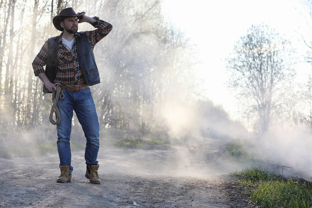 A cowboy in a thick smoke on the road - Foto, imagen