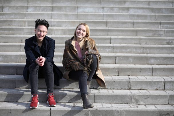A couple of friends are sitting on the steps - Zdjęcie, obraz
