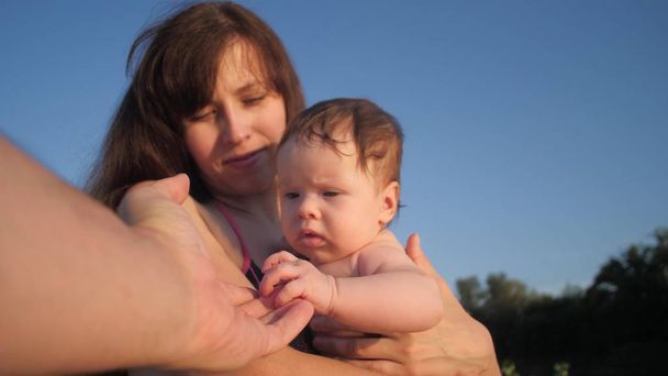Anne Bebek silah babasının elini bebek için dışarı uzanır tutar - Fotoğraf, Görsel