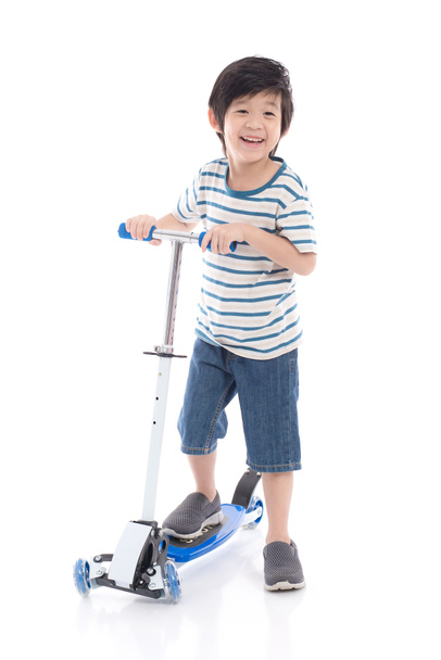 Cute Asian boy riding a scooter on white background isolated - Photo, Image